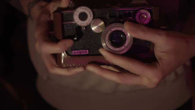 A photographer is holding a vintage Argus Rangefinder Camera, emanating retro photography vibes. Evokes a sense of timeless charm and old-school creativity. Capturing nostalgia concept.