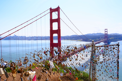 Love locks on fence of Golden Gate Bridge scenic viewpoint. Calfornia landmark. Romantic tradition.