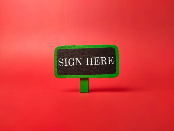 istock Colored sign board with the word SIGN HERE 2116136000