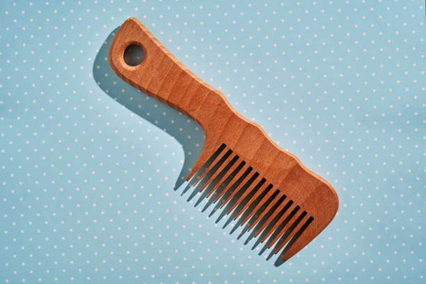istock Wooden comb on a pink polka dot background. 2116202545