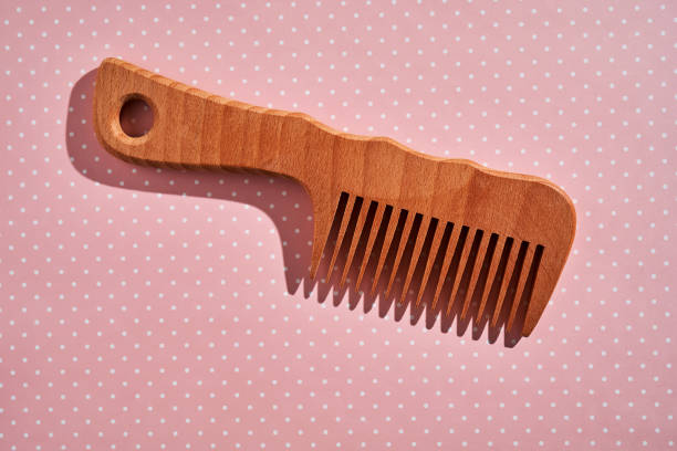 istock Wooden comb on a pink polka dot background. 2116203566