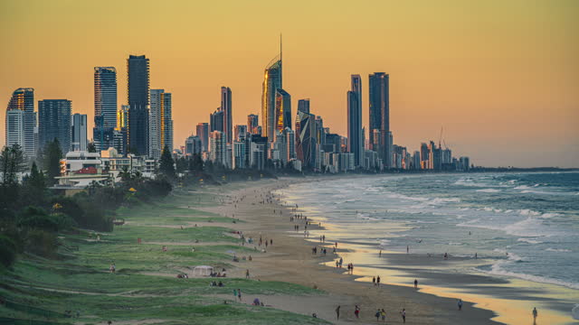 4K Footage Time lapse of Gold Coast Skyline and luxury buildings cityscape with crowd people enjoying at Burleigh Beach from North Burleigh suburbs of the Gold Coast, Burleigh Heads, Queensland, Australia