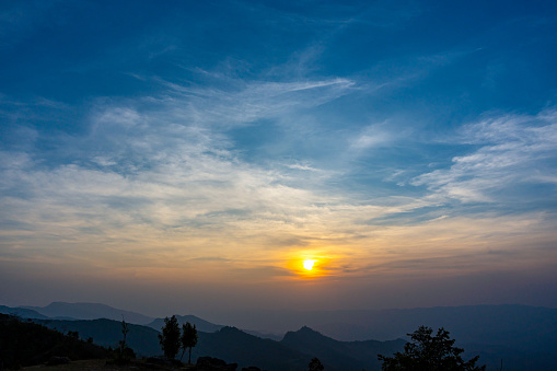 Scenic mountain landscape and bright sunrise or sunset sky over the horizon. Natural skyscape background