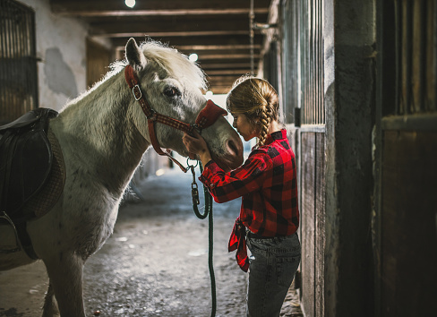 a young girl spends her time on her ranch and takes care of her horse