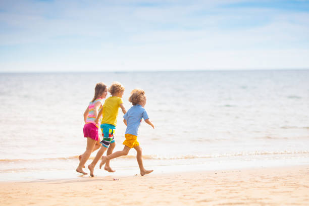 Child playing on tropical beach. Little boy with bucket and spade at sea shore. Family summer vacation. Kid building sandcastle. Water and sand fun for children. Kids play, build castle on ocean coast