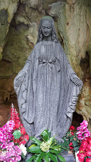 Black statue of the Virgin Mary in the grotto of Tritis attracts many pilgrims. Smiling face of black status Mary. Java, Indonesia
