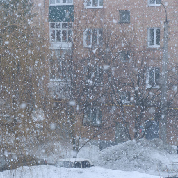 Heavy snowfall in front of the house with windows. Soft focus