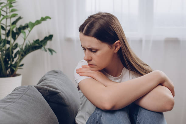 istock Frustrated confused woman feels unhappy, problems in personal life, quarrel break up with boyfriend and unexpected pregnancy concept. Anxious worried young female sitting alone on couch at home 2116388432