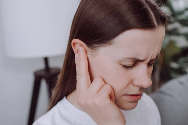 Close up of ill upset young caucasian woman have ear pain or earache, female suffering painful otitis from loud or noisy sound, inflammation. Health care nerve deaf eardrum disease. Tinnitus concept stock photo