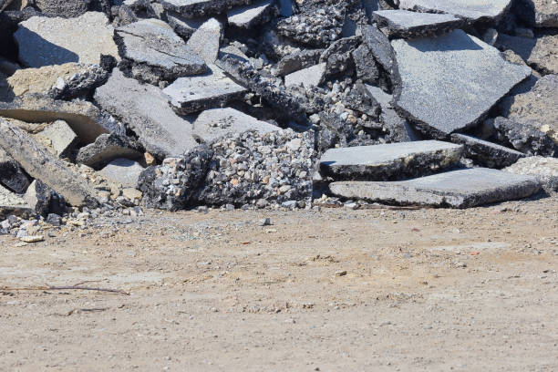 istock Cracked asphalt pieces after demolition of a road surface in a construction site 2116518634