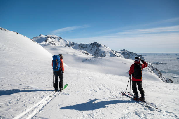 istock Ski mountaineers prepare to descend slope 2116548838