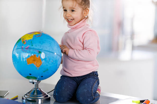 Happy little girl learning about the Globe at home.