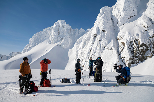 Ski mountaineers ascending snowcapped mountain across glacial plain