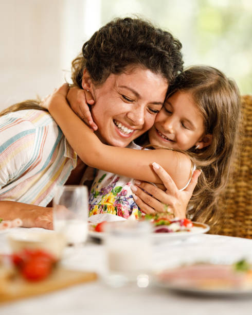 istock Happy single mother and daughter embracing during breakfast at home. 2116552919