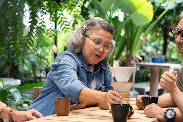 istock Asian senior talking and drinking coffee at garden 2116595626
