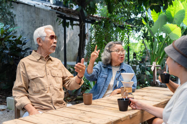istock Asian senior talking and drinking coffee at garden 2116595628