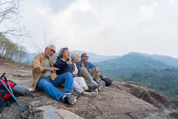 istock Asian senior relaxing and sitting on hill 2116601352