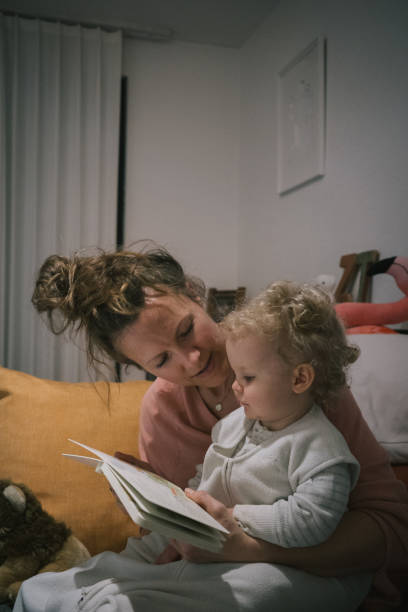 istock Mother and baby read book together 2116629505