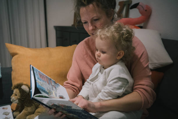 istock Mother and baby read book together 2116630536