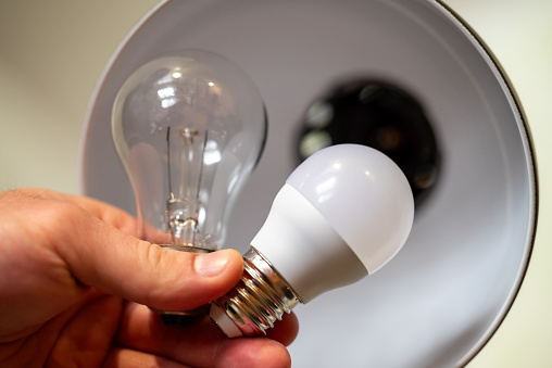 Replacing old light bulb with new, energy-efficient LED, making home`s lightning better