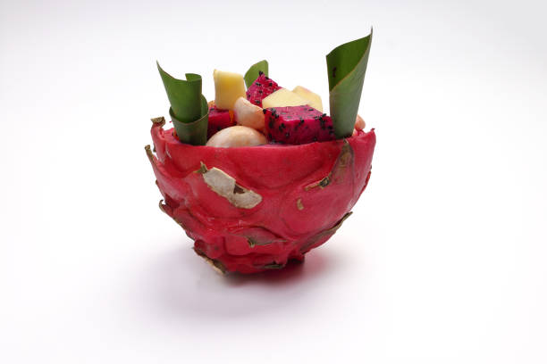 Beautiful Mangosteen mango dragon fruit cube fruit salad in dragon fruit skin bowl on white background