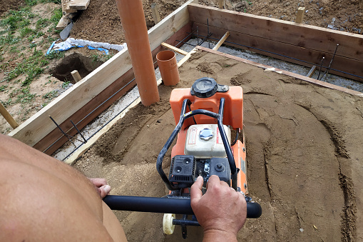 Working with a vibrating machine and equipment, soil compaction with a vibrating plate.new