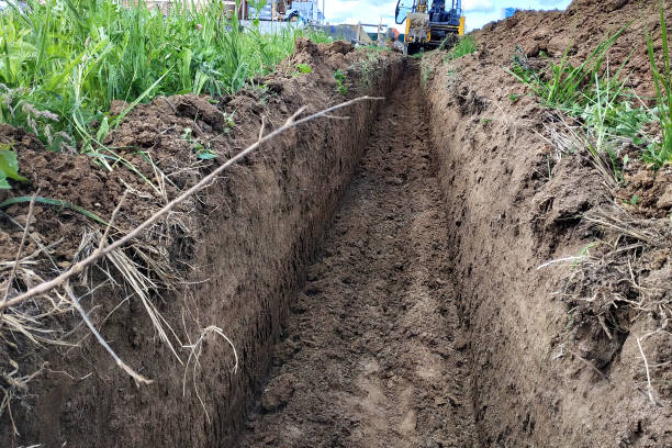 istock Construction excavator digging a shallow groove for electrical wiring or cable. 2116700002