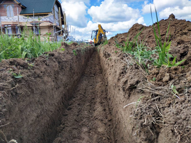istock Construction excavator digging a shallow groove for electrical wiring or cable. 2116700546