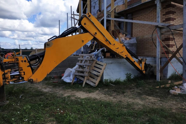 istock The excavator digs a dart around a building that is under construction. 2116702140
