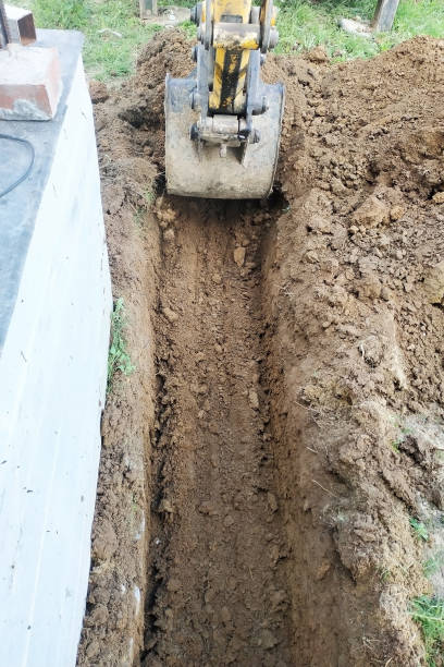 istock The excavator digs a small trench in the yard. 2116706360