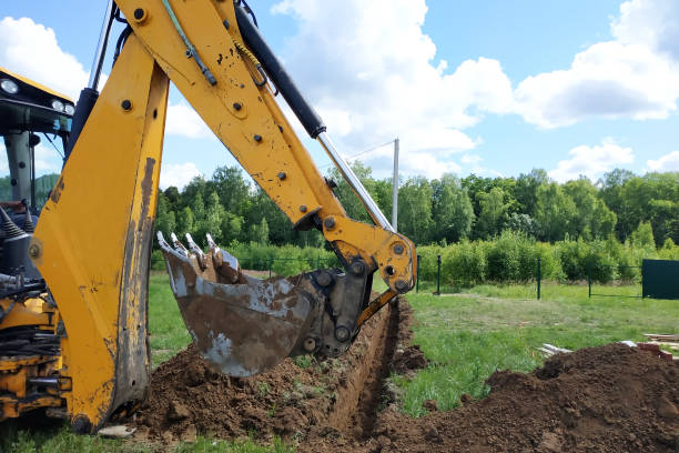 istock A yellow excavator digging a trench on the construction site, a close-up, against the sky. 2116706571