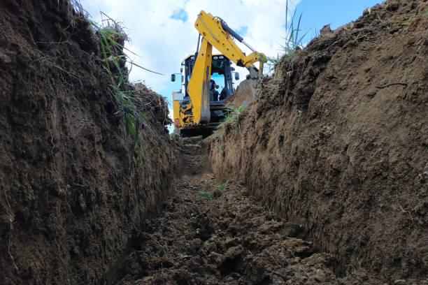 istock A yellow excavator digging a trench on the construction site, a close-up, against the sky. 2116708933
