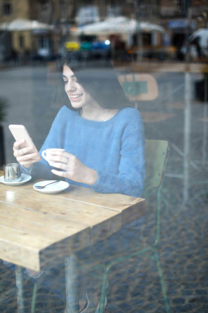 istock Woman texting at a cafe 2116711545