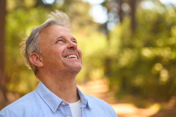 istock Peaceful Senior Man Relaxing Standing Amongst Nature In Forest Surrounded By Trees 2116723997