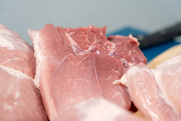 Pork meat cut into pieces lies on a cutting board. Pork meat close-up.