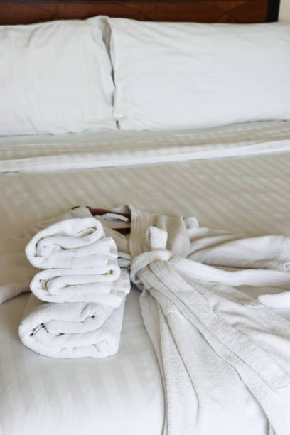 istock Image of cozy white dressing gown & folded towels on bedrobe 2116753057