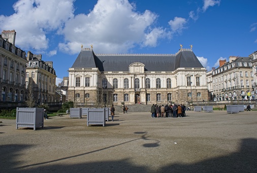 Rennes, France - Mar 24, 2024: Parliament building of Brittany in Rennes. People walking in Rennes on sunday. Streets and buildings. Lifestyle in the urban area. Sunny spring day. Selective focus