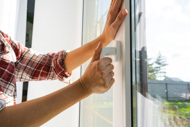 istock The hand holds the handle of a plastic double-glazed window, closing and opening the window with a rotary mechanism, the position of the handle for ventilation, micro-ventilation 2116816489