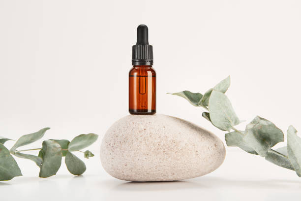 istock Glass amber vial on spa stone on cream background. 2116816757