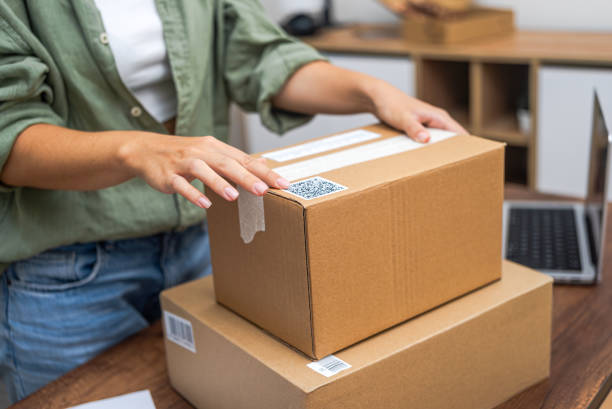 istock Woman hands attach QR code to package, essence of e-commerce delivery and online shopping. 2116819455