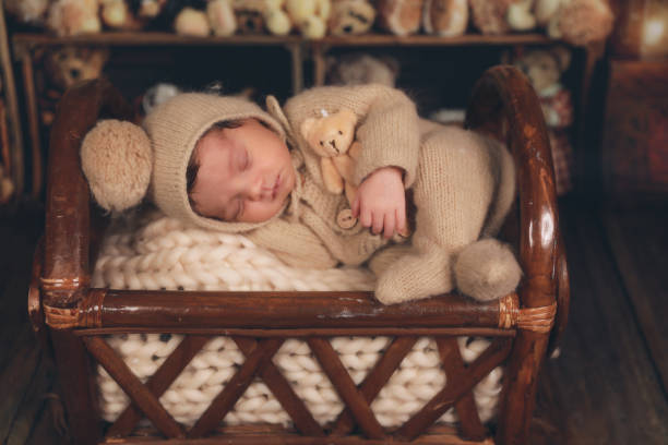 a newborn baby sleeping in a basket with teddy bears