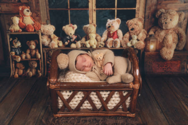 a newborn baby sleeping in a basket with teddy bears