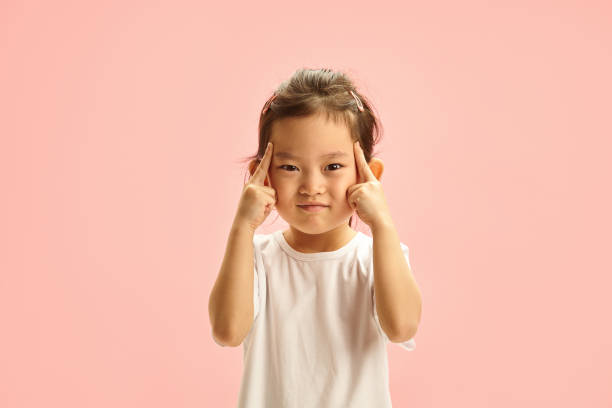 istock Korean child girl frowning expresses deep concentration or attempt remember something, pressed fingers against her temples, trying remember something forgotten, showing intense focus or mental strain 2116850380
