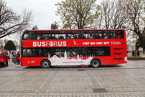 Tourists ride hop on hop off bus tour in Sultanahmet neighborhood of Istanbul, Turkey.