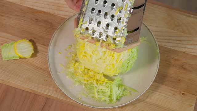 The chef grates colorful zucchini on a coarse grater and prepares a healthy meal. Healthy eating concept, vegetarian food, vegetables rich in vitamins, diet. Close-up, top view