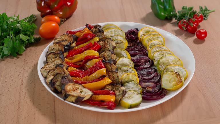 Baked vegetables eggplants, red and yellow peppers, zucchini, onions, wooden table on background vegetables, vegetable salad, eggplant dishes, vegetarian food, appetizer, close-up