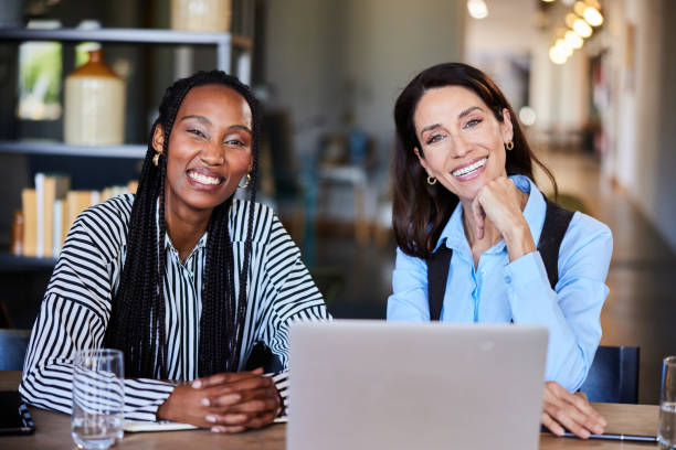 istock Two diverse businesswomen smiling while working together on a laptop 2116894201