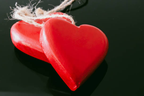 Two heart chains sits on a black backround