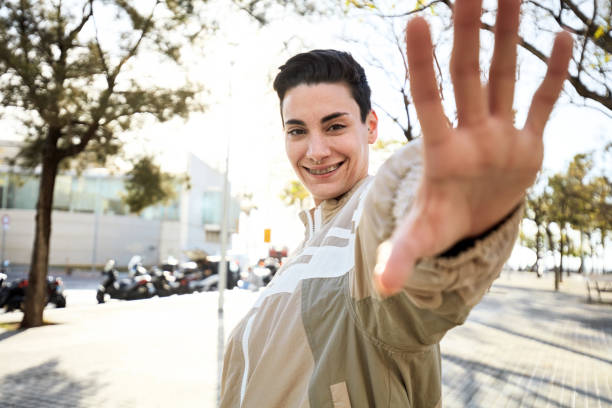 istock Smiling stop gesture in outdoor sunshine 2116937898