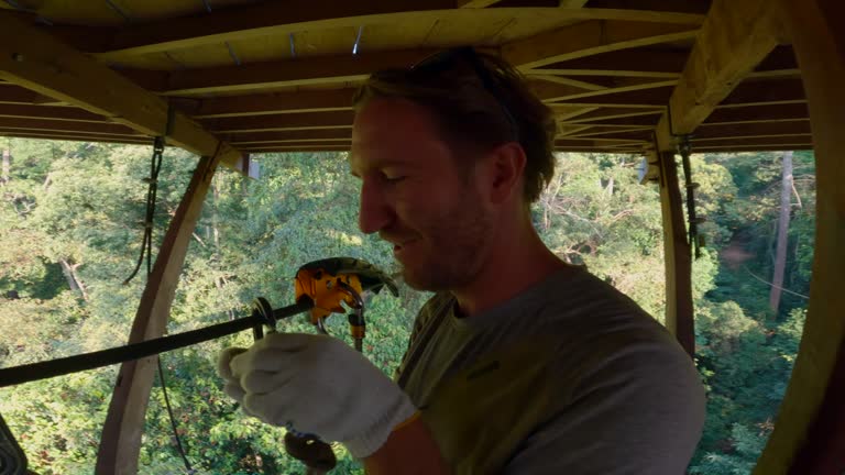 Adventurous male takes a selfie while zip lining over a tropical rainforest